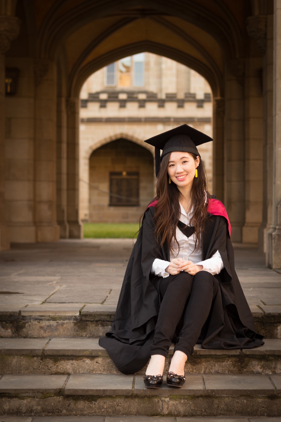 UC graduate learning sitting on stairs